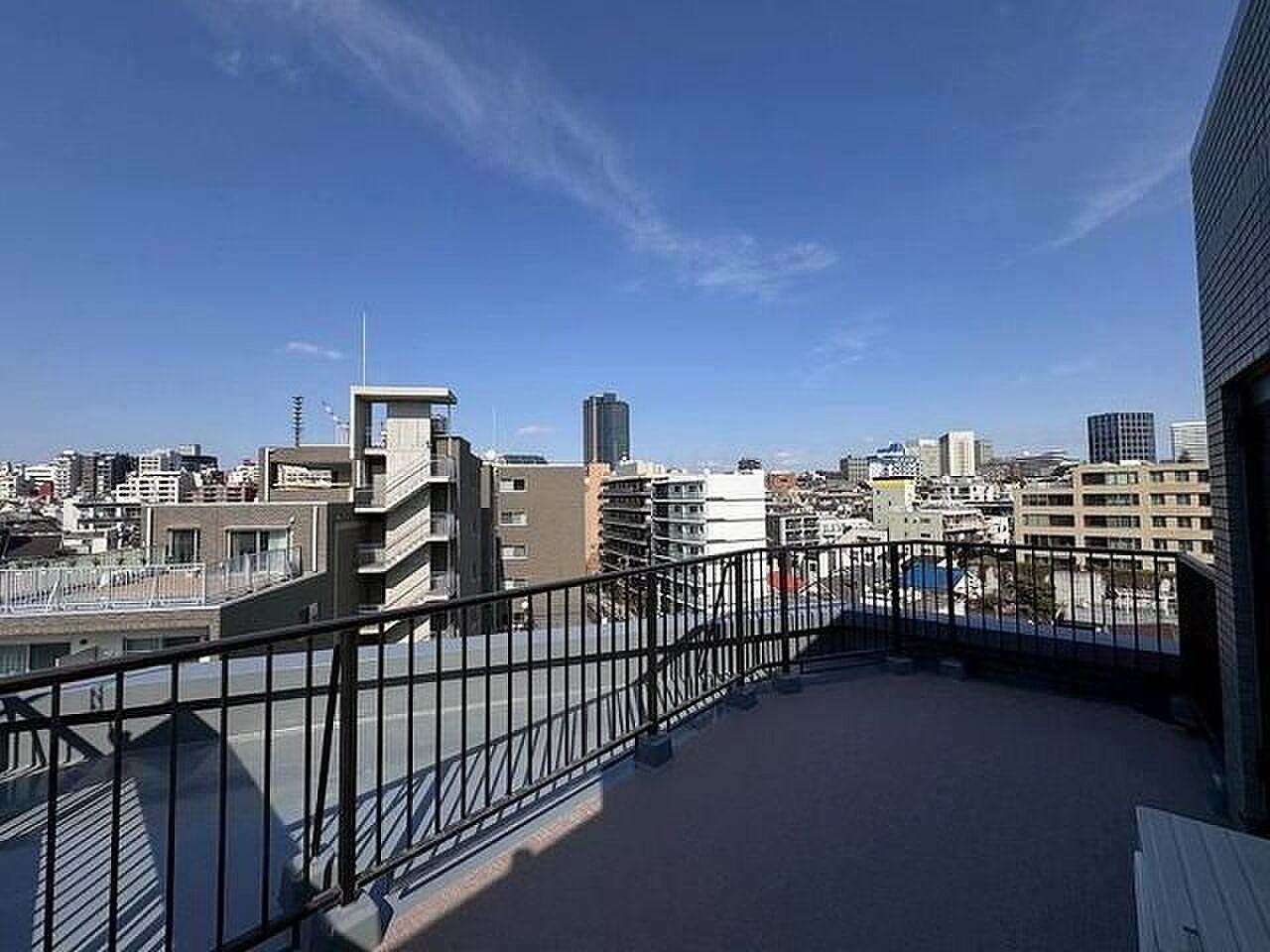 最上階8階、手すりの向こうに街が広がる約21㎡の屋外