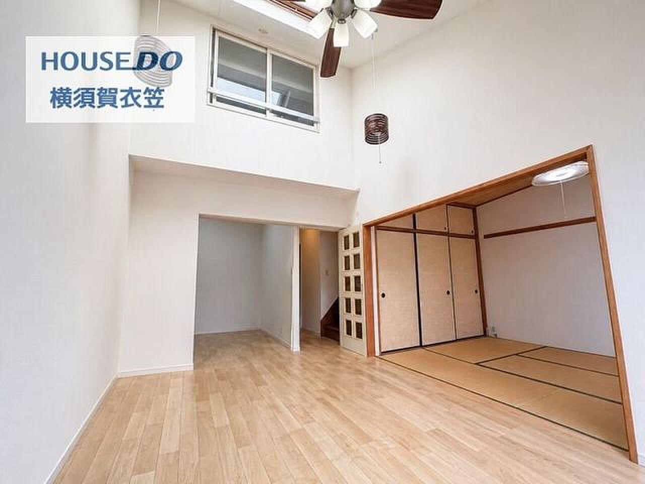 高窓から光が落ちるリビングの、その奥に二階への階段がある