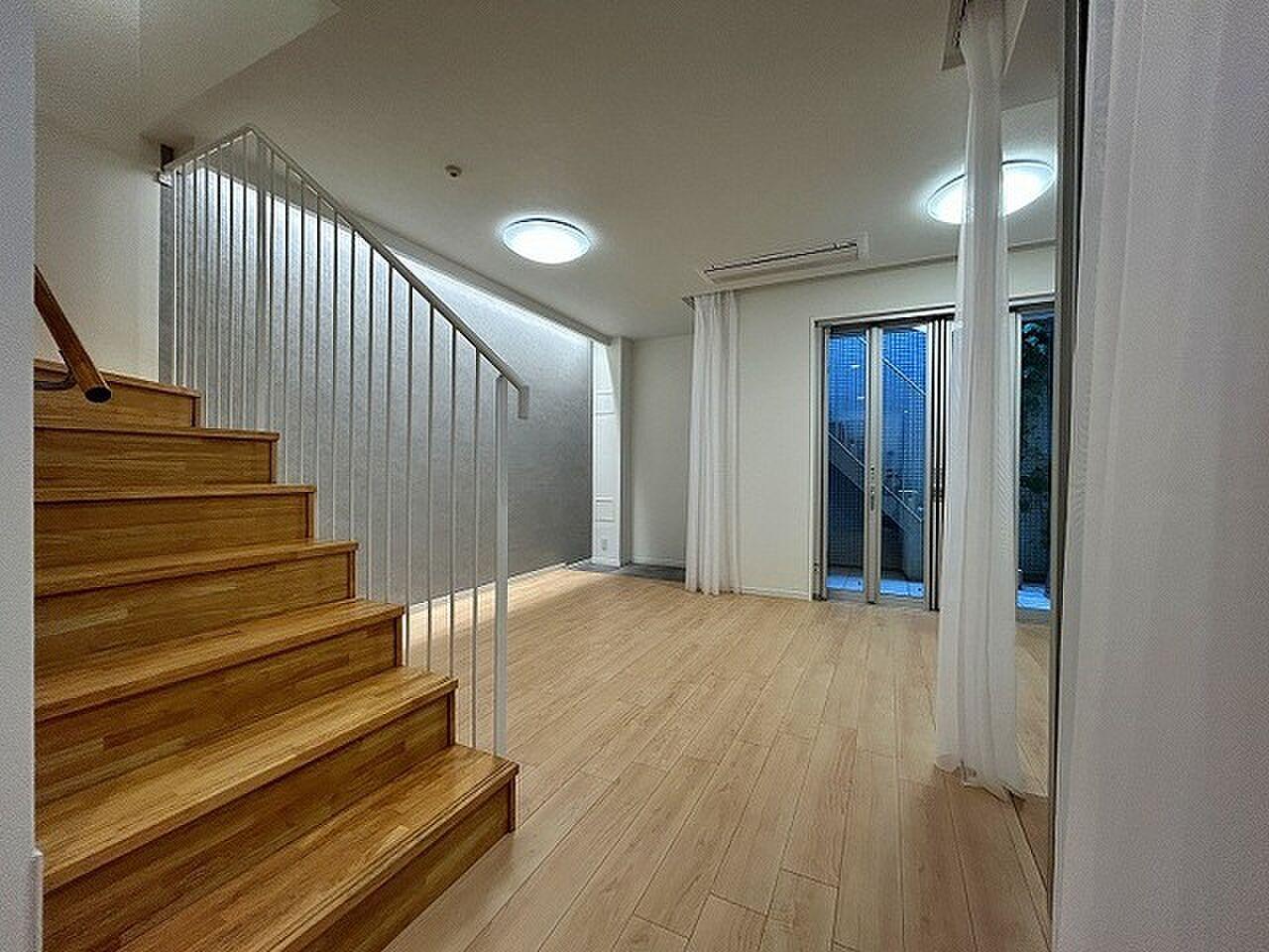 木の階段が居間の真ん中に立つ、戸建てのようなメゾネット