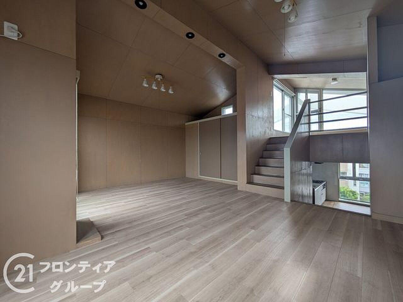 勾配天井のリビングから、階段を上がってルーフテラスへ