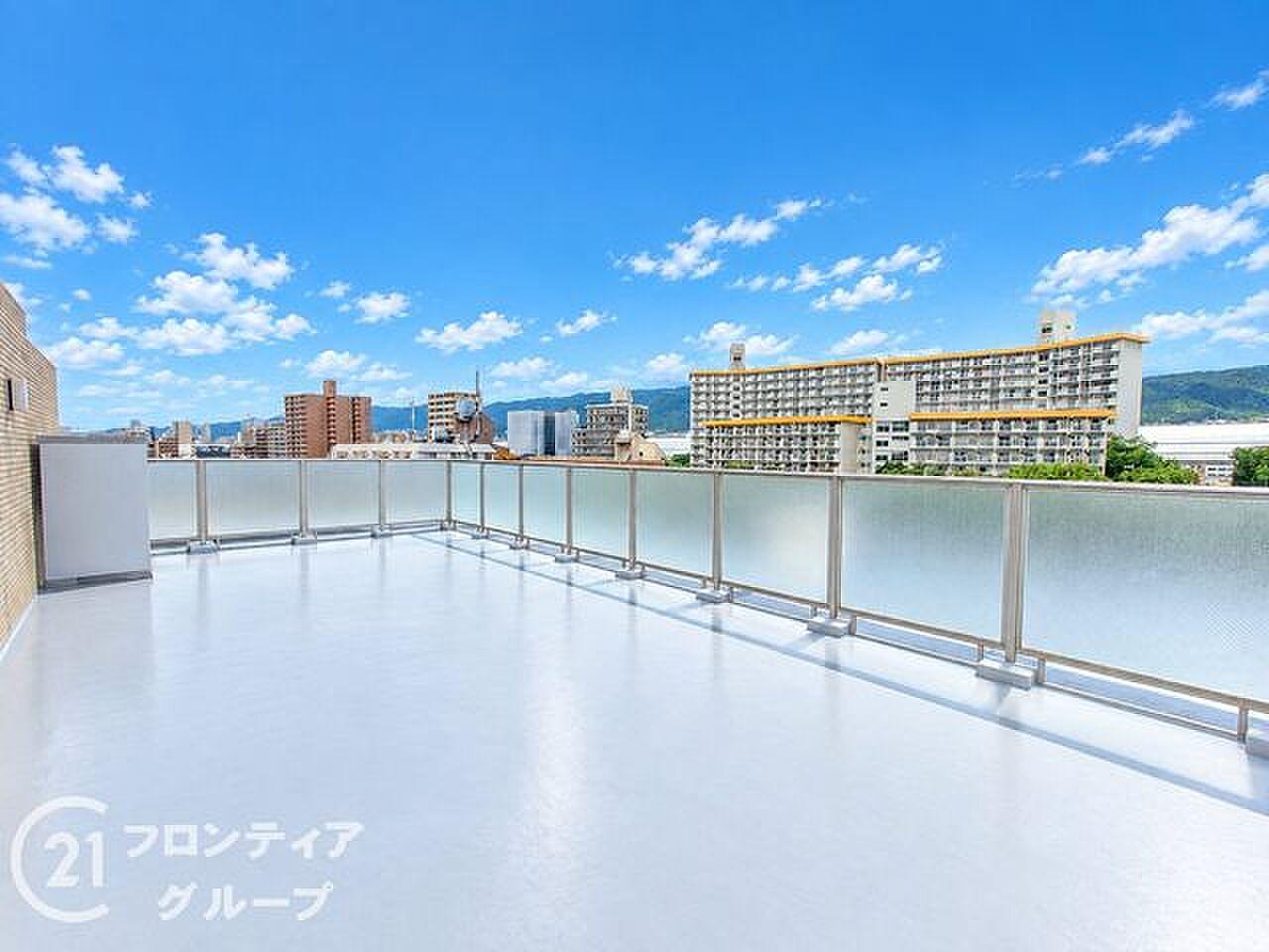 49㎡の白い床の上、空とフェンス越しの街並みだけがある