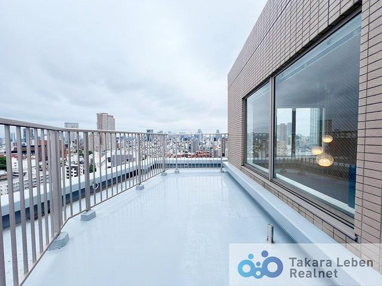 階段を上がった先、手すりの向こうに街が水平に広がる
