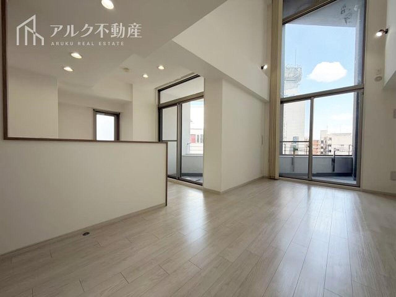 上階の窓辺から光が落ちてくる、二層分のリビング