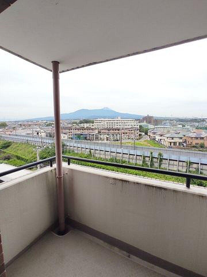手すりの向こうに市街地と山並み。約74㎡の屋上を、まるごと自分の庭にする暮らし