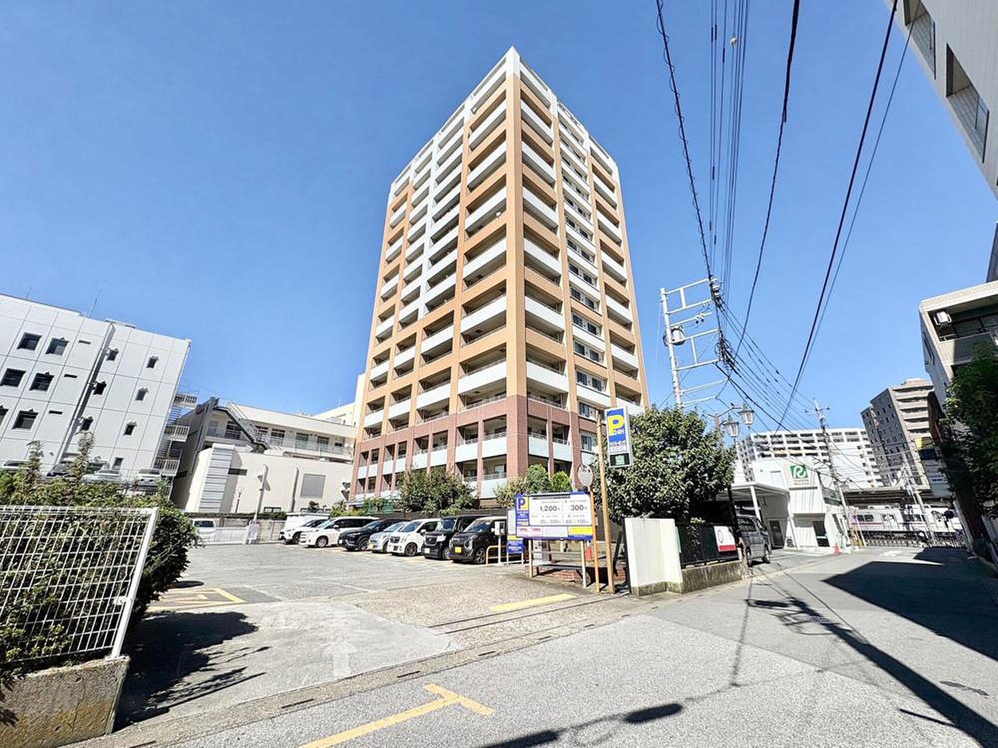 18階、手すりの向こうに屋根が連なる街が広がる