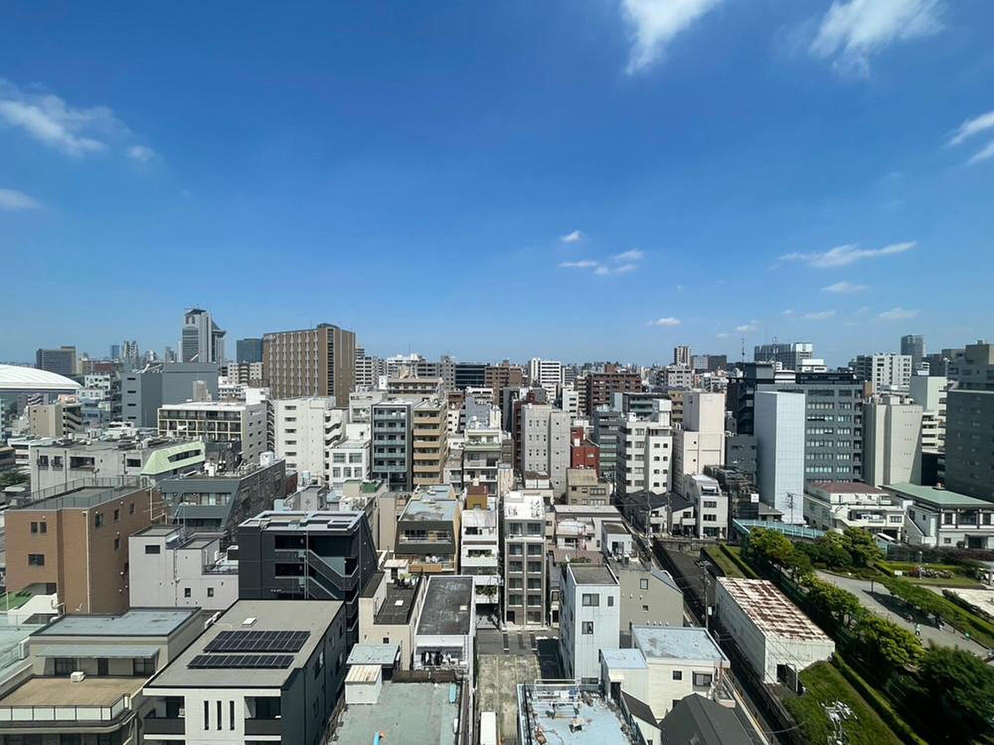 ラティス越しに高層ビル、足元は砂利とタイルの空中庭園