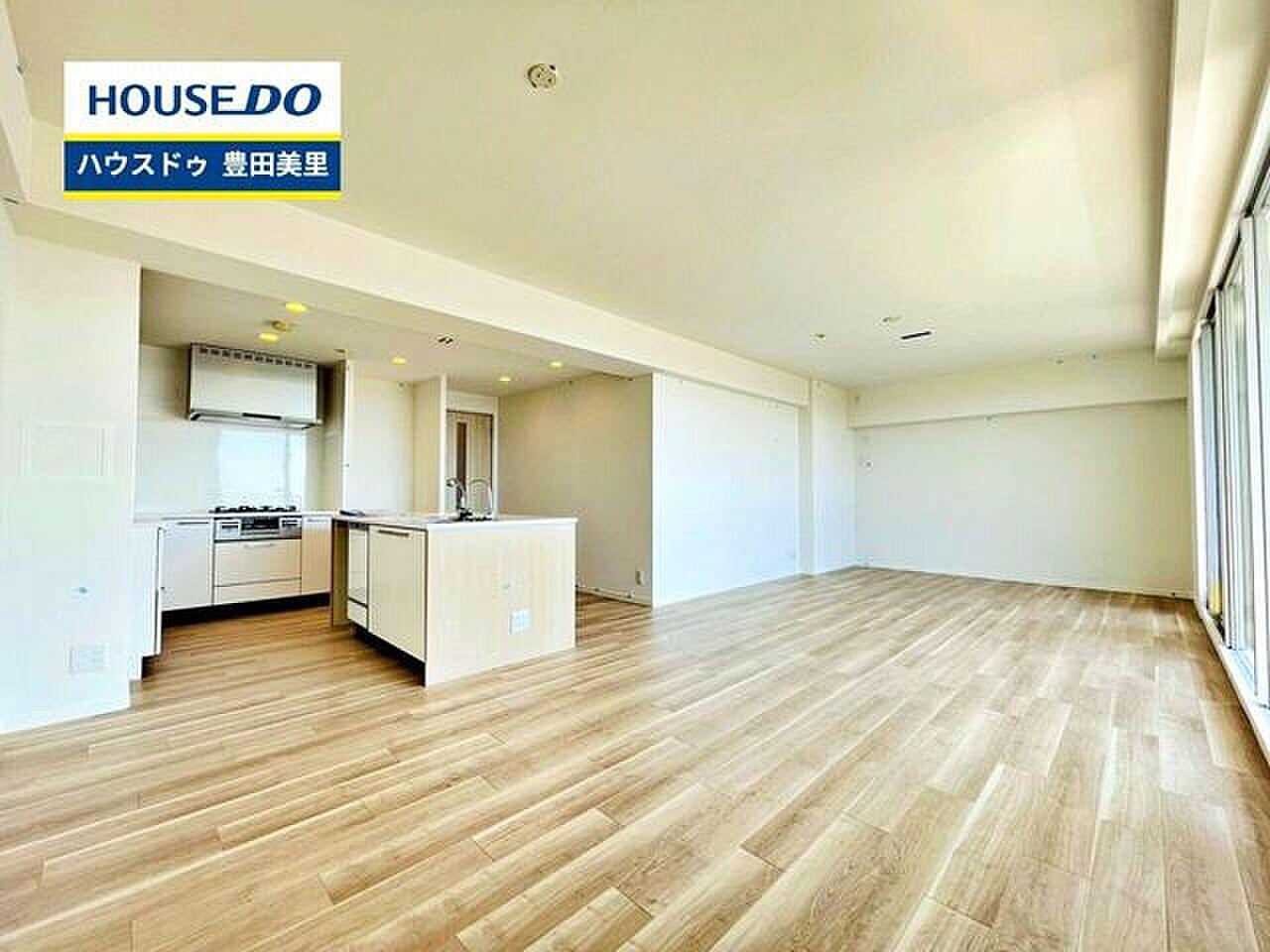 最上階15階、24.6帖のLDKの真ん中に立つ、白いアイランドキッチン