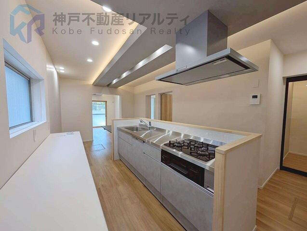 三口コンロのアイランドを囲んで、造作テーブルでそのまま食卓へ