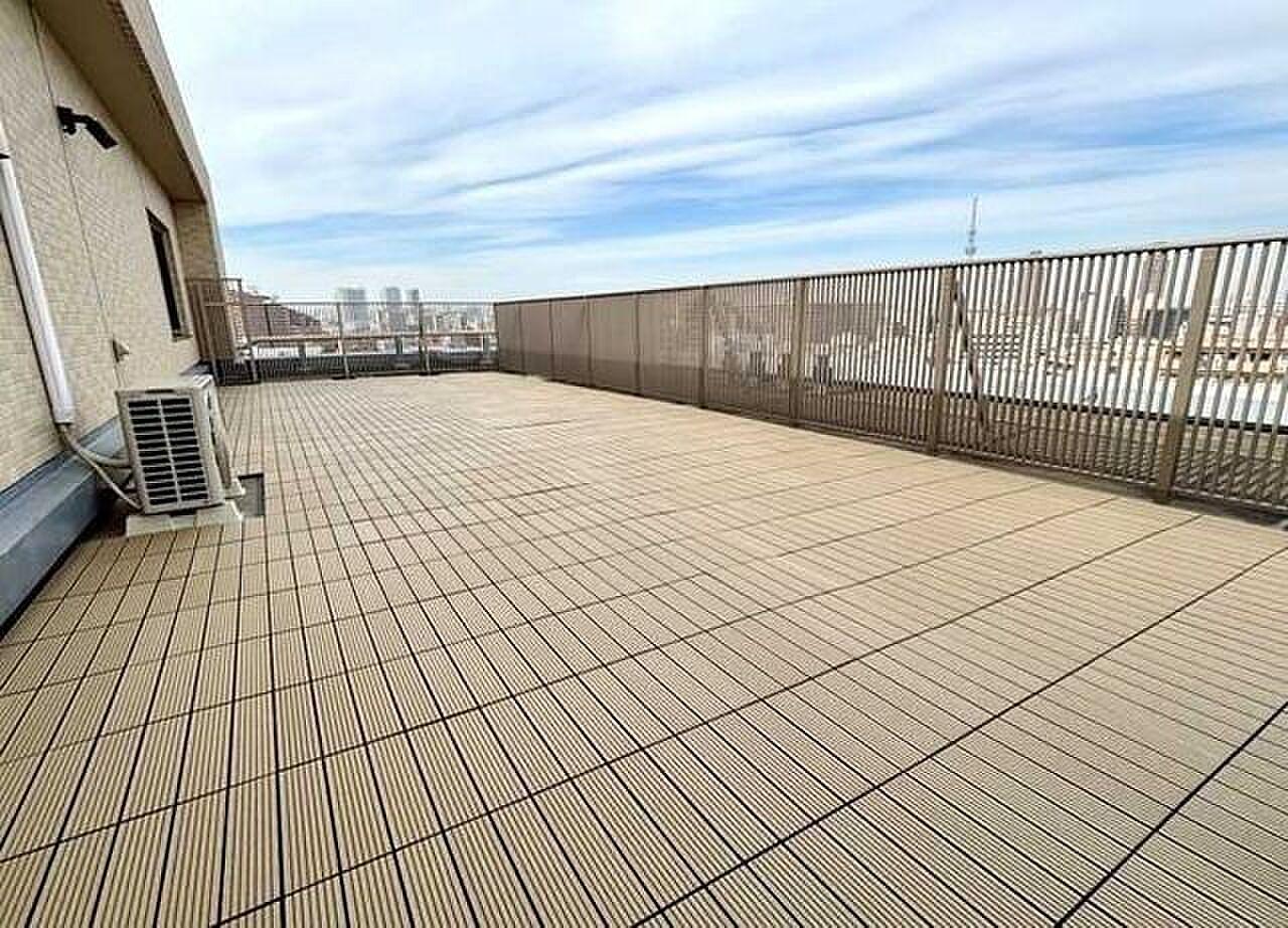 デッキが奥まで続く空の平場。手すりの向こうにスカイツリーの影
