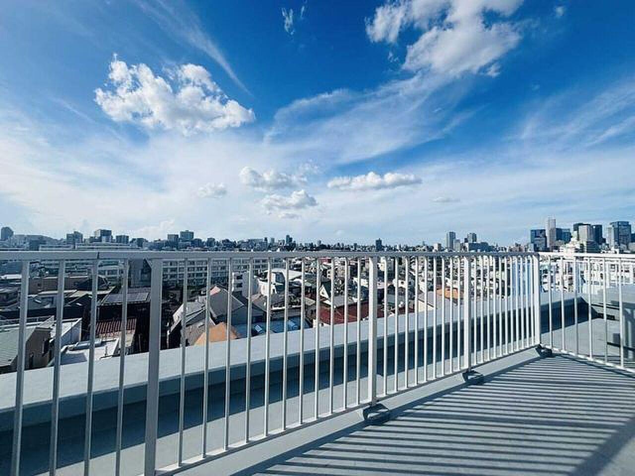 最上階の角、手すりの先はまるごと空。渋谷の街並みが視界の下に広がる屋外リビング