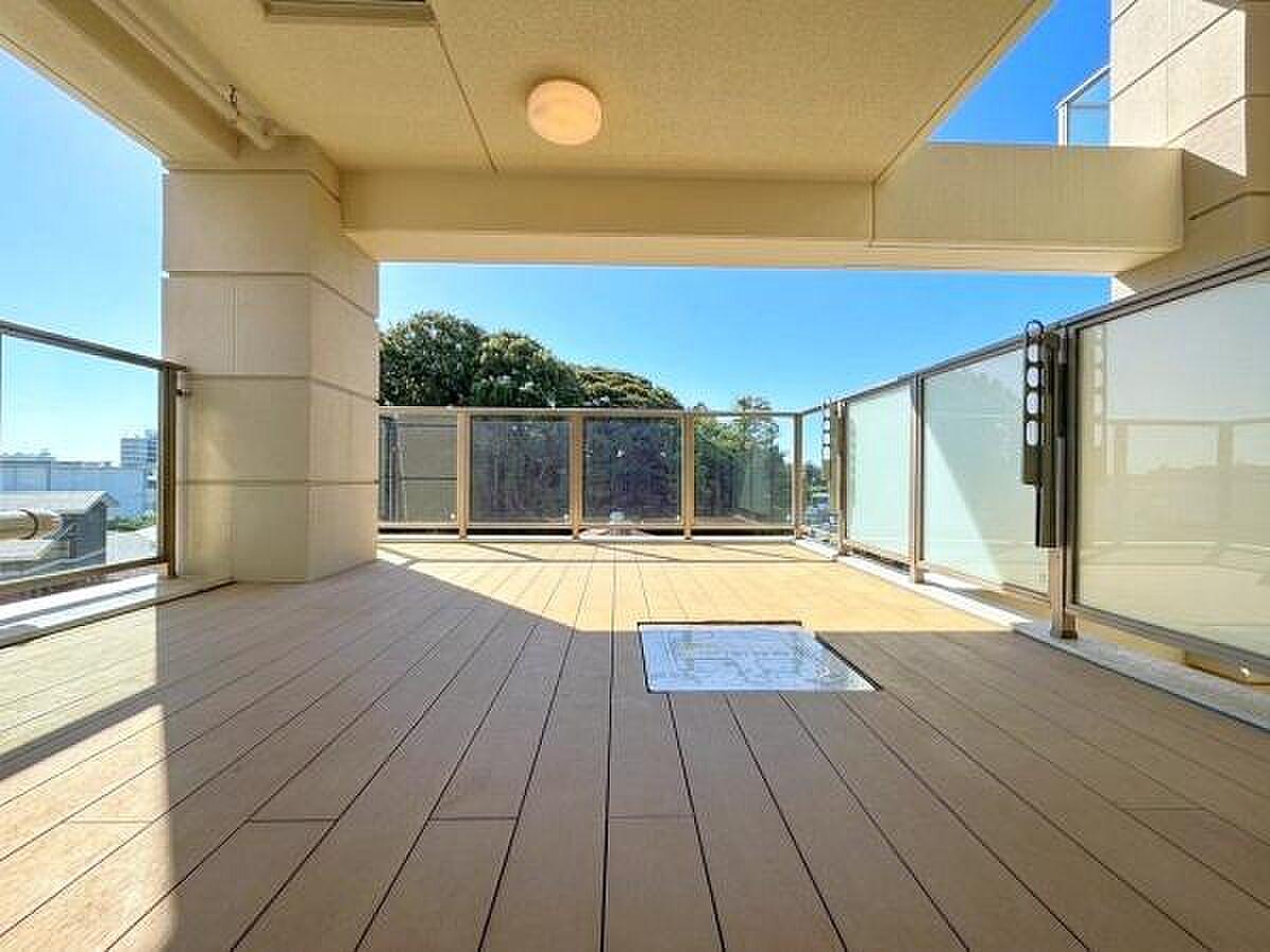 屋根のあるウッドデッキから、正面の緑と空だけを眺める